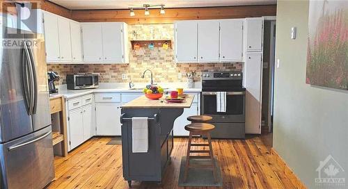 You know that islands in kitchens were designed to keep un qualified bystanders the heck out of your way, while they have a drink and tell you about their day. - 48 Sunrise Road, Killaloe, ON - Indoor Photo Showing Kitchen