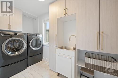 Convenient second floor laundry room with custom cabinets and sink. - 109 Spindrift Circle, Manotick, ON - Indoor Photo Showing Laundry Room