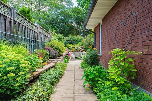 Side walkway is manicured with greenery and invites the entry to the backyard along the side of the garage. - 28 Sunset Drive, Simcoe, ON - Outdoor With Exterior