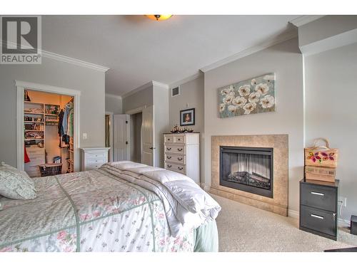 7922 Okanagan Landing Road Unit# 602, Vernon, BC - Indoor Photo Showing Bedroom With Fireplace