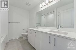 Quartz counters in main bathroom and sleek modern fixtures - 
