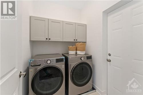 Main floor laundry with upper cabinets - 723 Odyssey Way, Ottawa, ON - Indoor Photo Showing Laundry Room