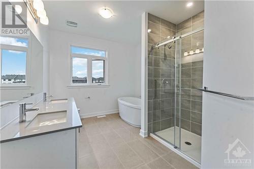 Luxury ensuite with double sink vanity, quartz counters, stand  alone tub, glass/ceramic shower and upgraded tile - 705 Rosales Ridge, Ottawa, ON - Indoor Photo Showing Bathroom