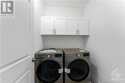 2nd floor laundry room with cabinets above washer dryer - 705 Rosales Ridge, Ottawa, ON - Indoor Photo Showing Laundry Room