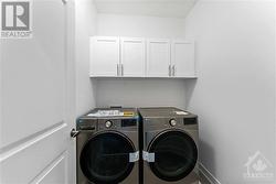 2nd floor laundry room with cabinets above washer dryer - 