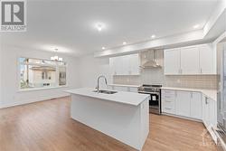 Bright white kitchen with upgraded quartz  countertops and hardwood flooring - 