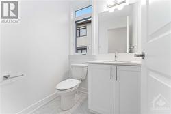 Powder room with quartz countertop and upgraded tile - 