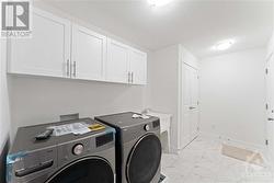Main floor Laundry/ mud room with cabinets above for storage - 