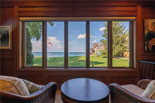 Vaulted ceilings accentuate the grandeur of the great room with prime waterfront views. Solid oak panelling offers a contrast to the cool blues of the water view. - 23 Winona Park Road, Stoney Creek, ON - Indoor