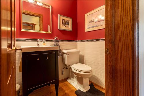 The main level powder room was updated in modern fixtures while a pop of red adds a dramatic design touch! - 23 Winona Park Road, Stoney Creek, ON - Indoor Photo Showing Bathroom