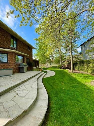The beautiful curved lines of the landscaping creates interest through all seasons. Irrigation front and back ensures everything remains green spring to fall. - 23 Winona Park Road, Stoney Creek, ON - Outdoor