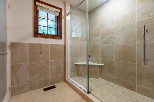 A low profile glass walk-in shower features bench seating. It's own linen closet separate from the large walk-in closet. - 23 Winona Park Road, Stoney Creek, ON - Indoor Photo Showing Bathroom