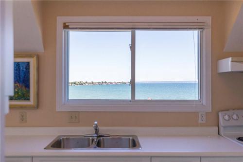 Looking out from the boathouse, enjoy the bright blue waters of Lake Ontario. - 23 Winona Park Road, Stoney Creek, ON - Indoor Photo Showing Kitchen With Double Sink