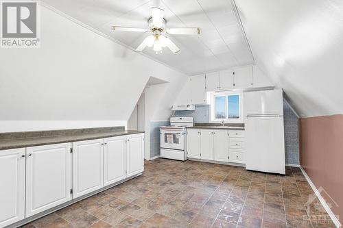 As you enter the second level apartment you will have access to this ample country kitchen with brand new fridge and stove. Notice the super long counter on the left. - 927-931 Laurier Street, Rockland, ON - Indoor Photo Showing Kitchen