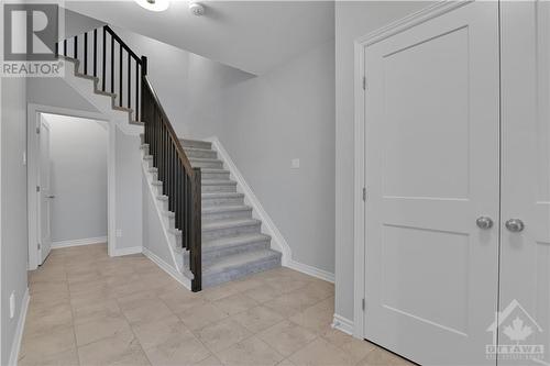 generous foyer with garage at left and stairs to basement straight ahead.  Easy to maintain ceramic tile and front closet at right - 800 Cap Diamant Way, Ottawa, ON - Indoor Photo Showing Other Room