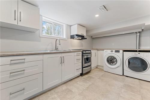 kitchen & updated appliances, with above grade windows letting in plenty of natural light. - 65 East 11Th Street|Unit #Lower Level, Hamilton, ON - Indoor Photo Showing Laundry Room