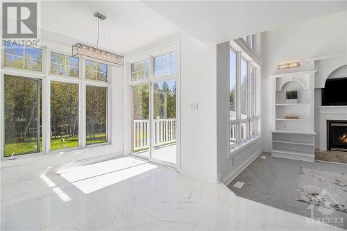 Patio door to the balcony for an impressive view of the backyard. - 202 Grey Fox Drive, Ottawa, ON - Indoor With Fireplace
