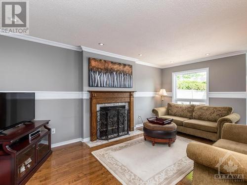 Family room off of the kitchen. Wood burning fireplace. - 9 Kinalea Crescent, Stittsville, ON - Indoor Photo Showing Living Room With Fireplace