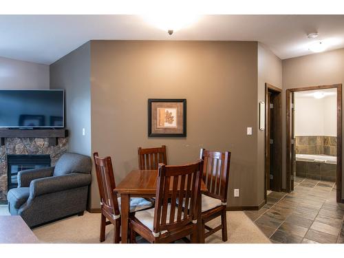 107 - 1545 Kicking Horse Trail, Golden, BC - Indoor Photo Showing Dining Room With Fireplace