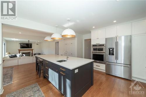 Renovated Kitchen with Custom Cabinets, Quartz Counters, Large Centre Island with Seating for 4, Stainless Steel Appliances and Hardwood Floors - 48 Marble Arch Crescent, Ottawa, ON - Indoor Photo Showing Kitchen With Stainless Steel Kitchen