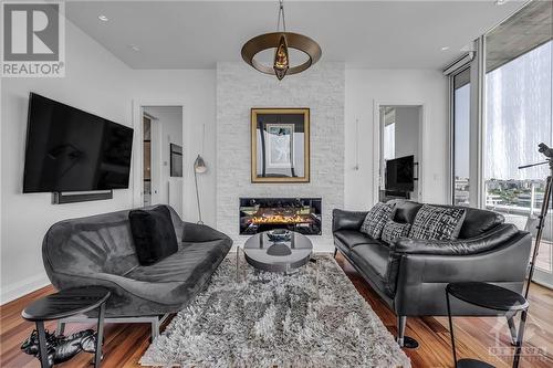 Living room is grandiose, centered around a tiled fireplace and surrounded by floor-to-ceiling wall-to-wall windows. - 111 Champagne Avenue S Unit#2004, Ottawa, ON - Indoor Photo Showing Living Room