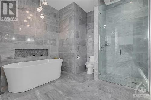 This hotel-inspired retreat is fully tiled and features a stand-alone soaker tub, a floating double vanity, walk-in glass shower and heated floors. - 111 Champagne Avenue S Unit#2004, Ottawa, ON - Indoor Photo Showing Bathroom