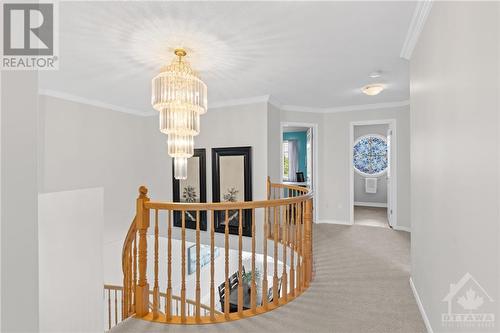 Carpeted upper level hallway, complete with a beautiful chandelier for lighting and a lovely view when you look down to the main level. - 2181 Des Grands Champs Way, Ottawa, ON - Indoor Photo Showing Other Room
