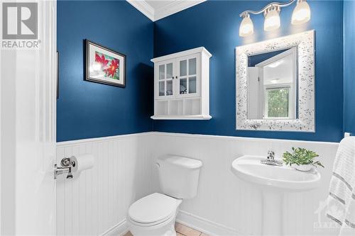 Elegant powder room featuring tile flooring and batten paneling that extends halfway up the walls, topped with a decorative chair rail. Perfect for when guests visit. - 2181 Des Grands Champs Way, Ottawa, ON - Indoor Photo Showing Bathroom