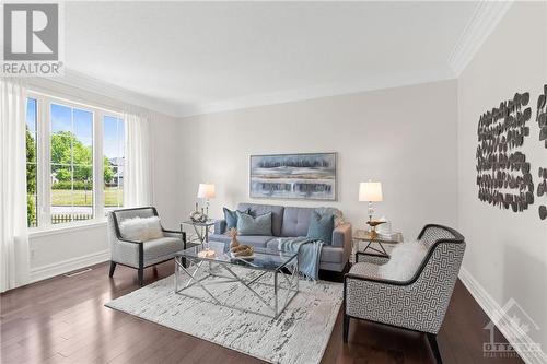 A beautiful family room perfect for entertaining guests or relaxing. It features hardwood floors and a large picture window that floods the space with natural light. - 2181 Des Grands Champs Way, Ottawa, ON - Indoor Photo Showing Living Room