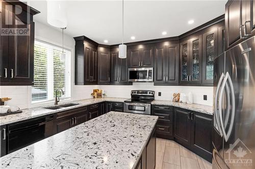 A beautiful, large island with quartz countertops invites you to bake and create delicious meals in this recently renovated kitchen. - 2181 Des Grands Champs Way, Ottawa, ON - Indoor Photo Showing Kitchen With Double Sink With Upgraded Kitchen