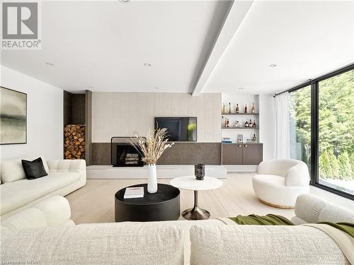 A focal point of the room, a stunning wood-burning fireplace stands as a testament to both form and function, adding warmth and ambiance while boasting timeless appeal. - 261 Whitmore Drive, Waterloo, ON - Indoor Photo Showing Living Room With Fireplace