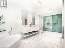 Spa-like ensuite featuring marble tile flooirng, double sinks, a jetted shower, and a luxurious soaker tub, even the most discerning buyer is sure to be impressed. - 