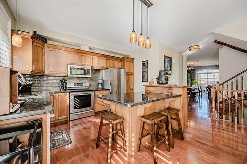 Island with granite, wine cabinet, bar stools included. - 5255 Dryden Avenue, Burlington, ON - Indoor Photo Showing Kitchen