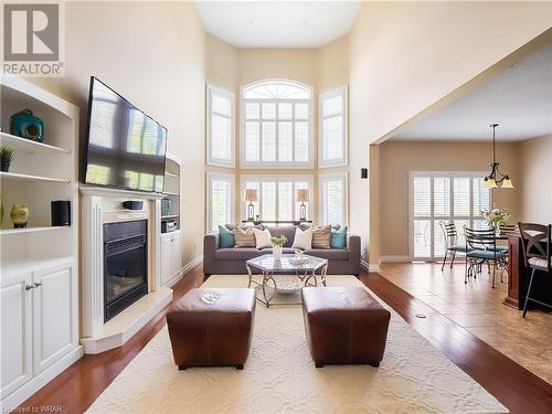 The 2-storey great room in unquestionably the showpiece of this stunning residence offering remarkable floor to ceiling windows and views to the upper level, a 2-sided gas fireplace, shared with the e - 110 Golf Course Road, Woolwich, ON - Indoor Photo Showing Living Room With Fireplace