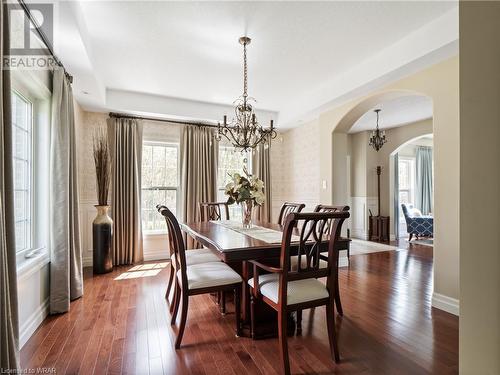 The spacious formal dining room is yet another part of this home which benefits from soft corners and an archway entrance and features a raised tray ceiling and the classic application of wainscotting - 110 Golf Course Road, Woolwich, ON - Indoor Photo Showing Dining Room