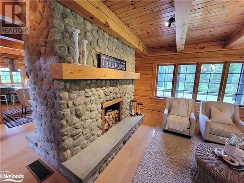 Double sided Stone Fireplace in Living area - 669 Skyhills Road, Huntsville, ON - Indoor Photo Showing Living Room With Fireplace