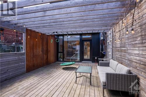 Backyard with a deck, pergola, climbing wall and monkey bars. The engineered steel wall works as a sound barrier and provides privacy. - 163 Irving Avenue, Ottawa, ON - Outdoor With Deck Patio Veranda With Exterior