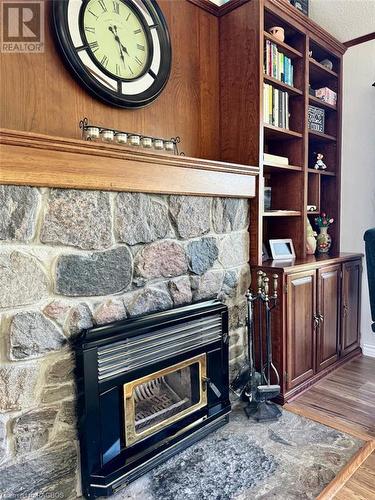 Beautiful air-tight insert offers warm wood heat to the entire main floor. - 47 Water Street, Northern Bruce Peninsula, ON - Indoor With Fireplace