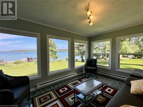 In front of the Great Room you find a four-season sunroom with wall-to-wall windows overlooking the property and Georgian Bay. - 47 Water Street, Northern Bruce Peninsula, ON - Indoor Photo Showing Living Room