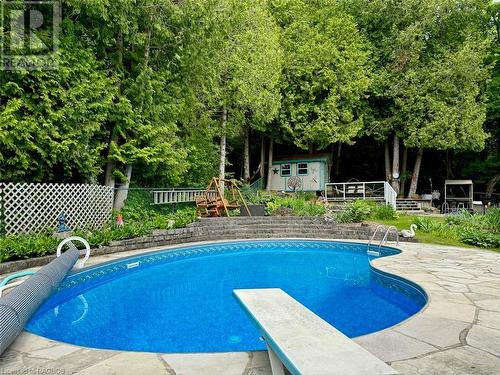 Kidney shape pool with newer liner, dive board, insulated cover and new heater. - 47 Water Street, Northern Bruce Peninsula, ON - Outdoor With In Ground Pool With Deck Patio Veranda With Backyard