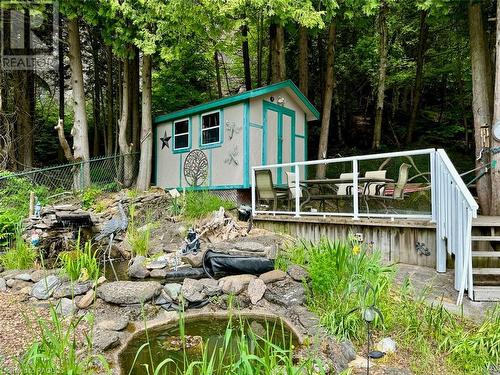 Pond feature with a waterfall and elevated deck area overlooks the pool area. - 47 Water Street, Northern Bruce Peninsula, ON - Outdoor