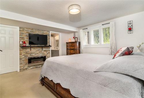 Lower level primary bedroom w fireplace - 91 Hedge Lawn Drive, Grimsby, ON - Indoor Photo Showing Bedroom