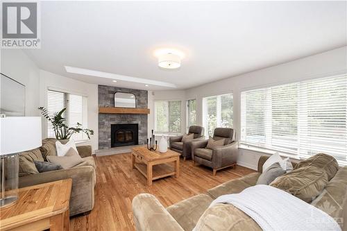 The family room features a skylight to bring in even more natural light in this welcoming & spacious area - 37 Slade Crescent, Ottawa, ON - Indoor Photo Showing Living Room With Fireplace