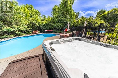 Enjoy moments in the hot tub or the in-ground pool! - 37 Slade Crescent, Ottawa, ON - Outdoor With In Ground Pool With Backyard