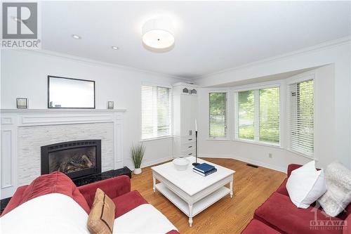 The formal living room with fireplace & large bay window is so sophisticated! - 37 Slade Crescent, Ottawa, ON - Indoor Photo Showing Living Room With Fireplace