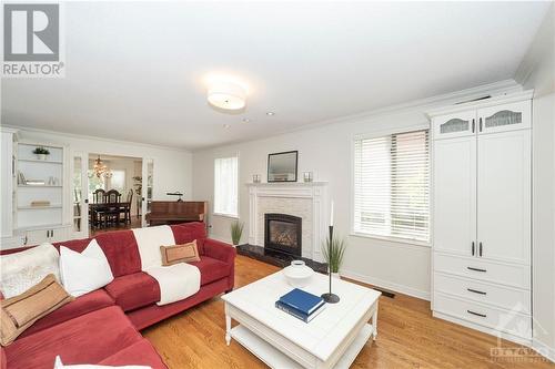 Built-in bookcases at the other end of the living room add storage & style - 37 Slade Crescent, Ottawa, ON - Indoor Photo Showing Living Room With Fireplace