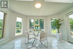 Bright eating area with windows, skylights and serene garden views. - 