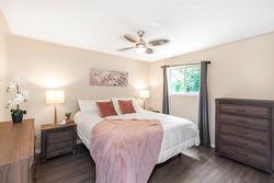 Primary bedroom with ceiling fan, view of backyard. - 