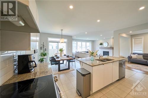 The upgraded kitchen, complete with SS appliances, granite countertops, a walk-in pantry, and an expansive kitchen island. - 348 Gloaming Crescent, Ottawa, ON - Indoor