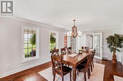 Spacious and elegantly appointed dining room with hardwood flooring, perfect for formal occasions and family dinners. - 